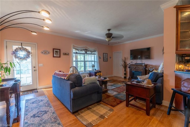 living room with light hardwood / wood-style flooring, crown molding, plenty of natural light, and ceiling fan