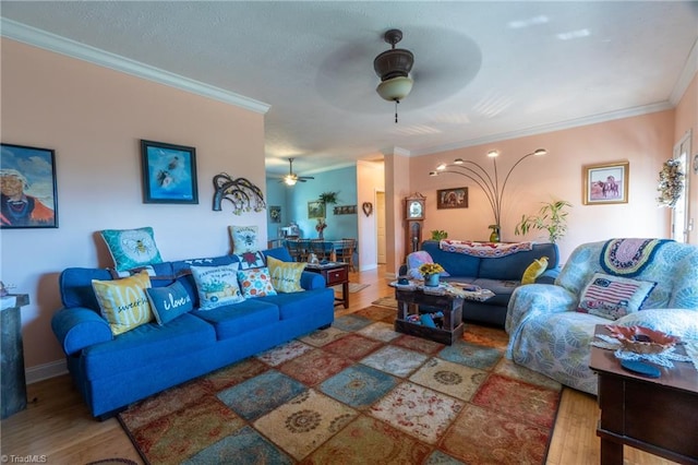 living room featuring crown molding, wood-type flooring, and ceiling fan