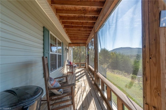 sunroom / solarium with beam ceiling, a mountain view, and wooden ceiling