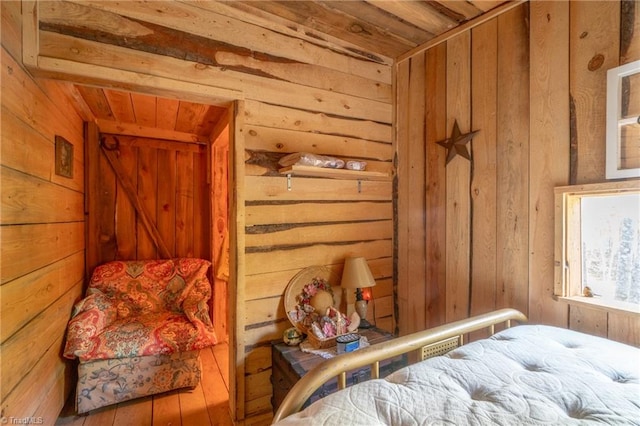 bedroom with wood ceiling, wood walls, and hardwood / wood-style floors