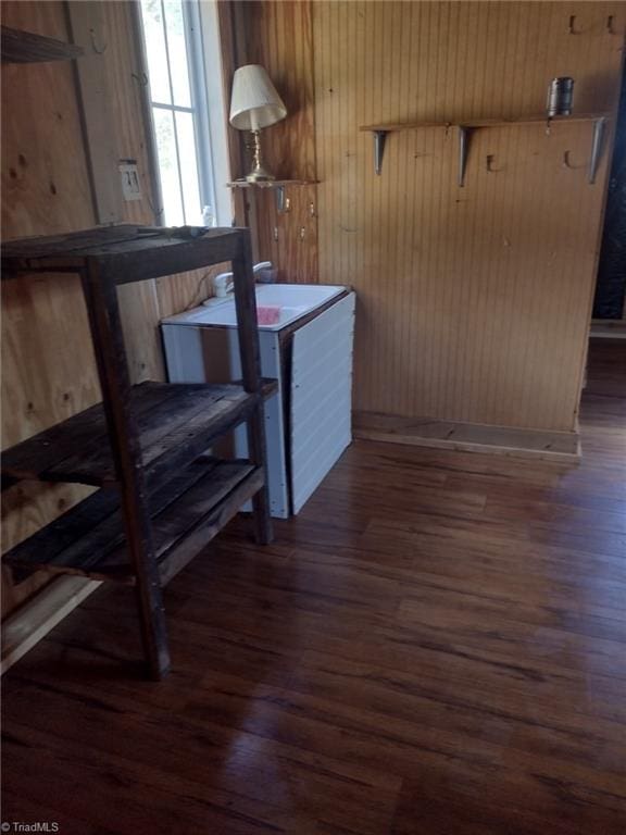 interior space featuring dark hardwood / wood-style flooring and wooden walls