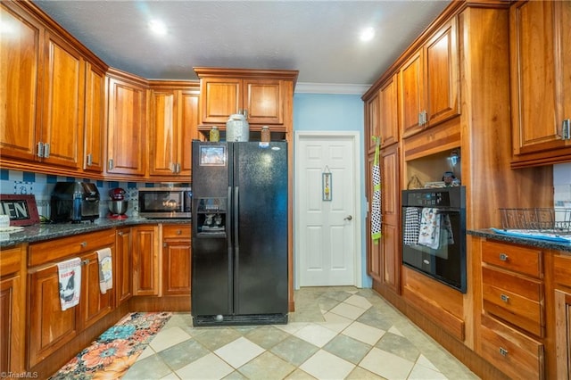 kitchen featuring crown molding, decorative backsplash, dark stone countertops, and black appliances