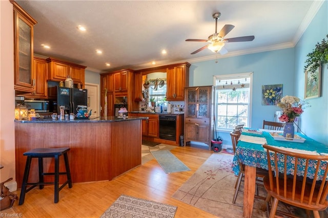 kitchen with ceiling fan, black appliances, a wealth of natural light, and light wood-type flooring