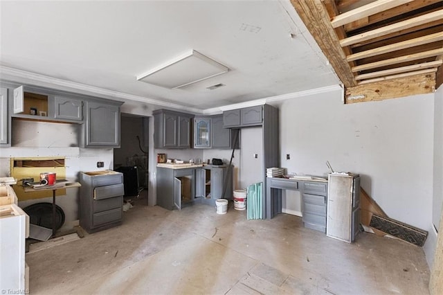 kitchen featuring concrete flooring, ornamental molding, and gray cabinets