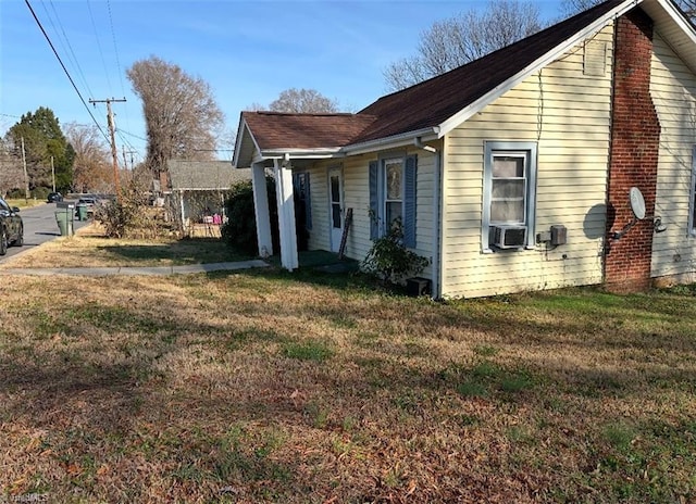 view of side of property with a lawn and cooling unit