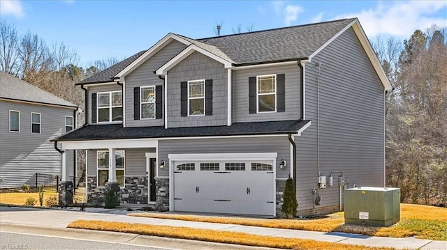 craftsman house featuring central air condition unit, a porch, and a garage