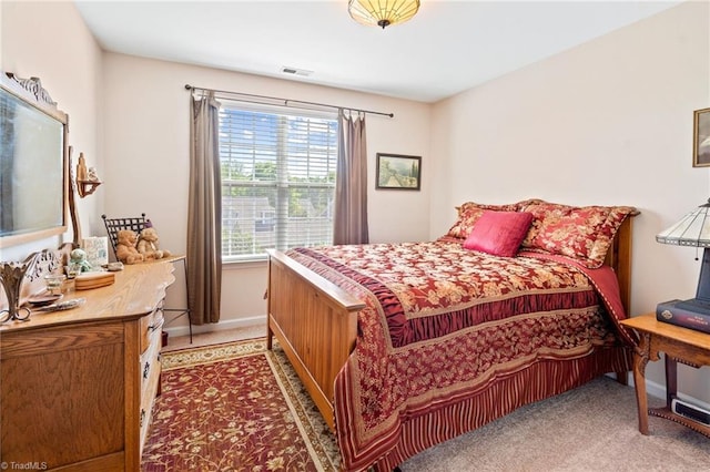 bedroom with light colored carpet, visible vents, and baseboards