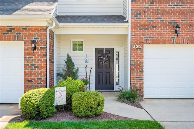 property entrance with a garage, brick siding, and a shingled roof