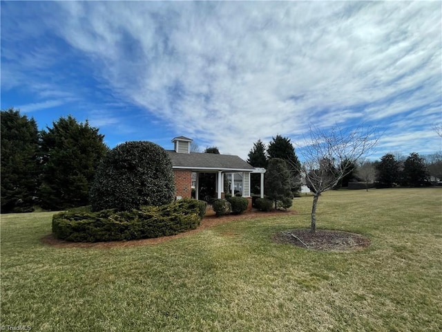 view of front of home featuring a front lawn and brick siding