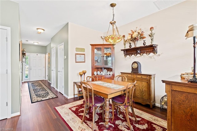 dining area featuring dark wood finished floors and baseboards