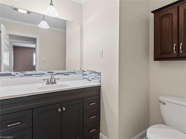 bathroom with vanity, toilet, backsplash, and ornamental molding