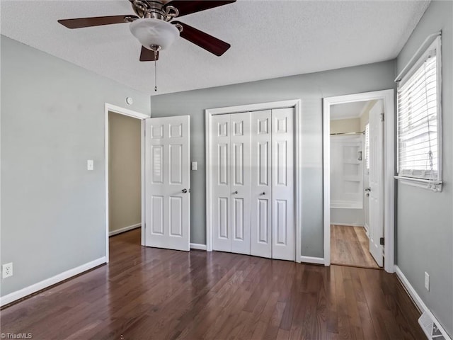 unfurnished bedroom featuring a closet, visible vents, baseboards, and wood finished floors