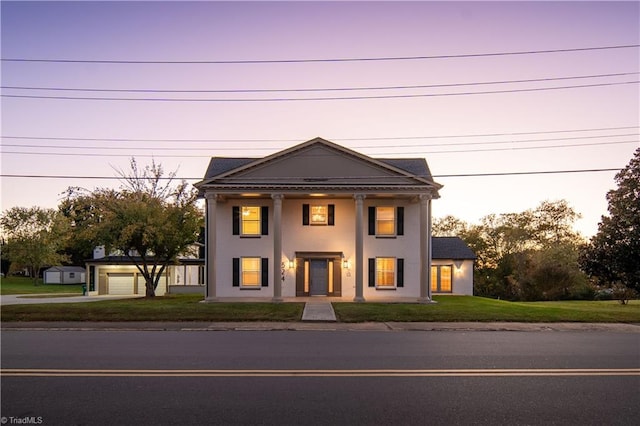 greek revival house featuring a yard and a garage