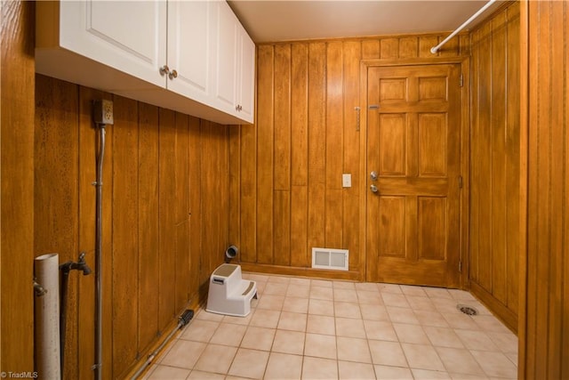 washroom with wooden walls and cabinets