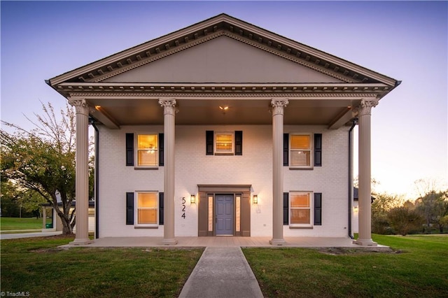 neoclassical / greek revival house featuring a lawn