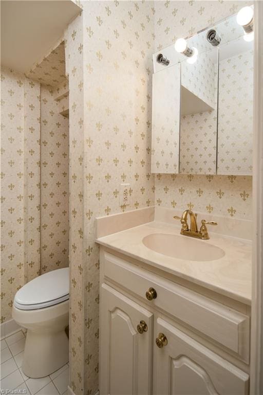 bathroom with toilet, vanity, and tile patterned flooring