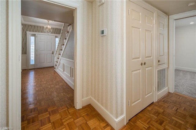 corridor featuring dark parquet flooring and a chandelier