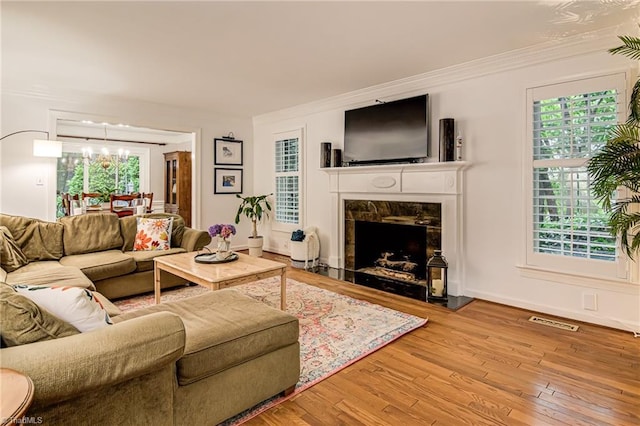 226 Cedar Trl, Winston-Salem, NC 27104 - living area featuring a chandelier, hardwood / wood-style flooring, a premium fireplace, crown molding, and baseboards
