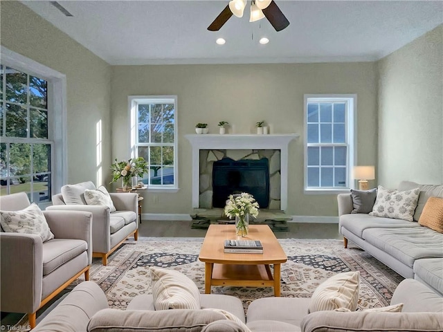 living room with light hardwood / wood-style floors, a fireplace, and ceiling fan