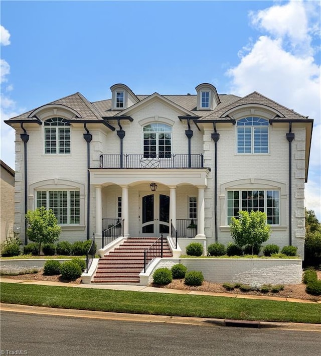 2990 Reynolds Sq, Winston-Salem, NC 27106 - french country style house featuring a balcony, stairs, french doors, and brick siding