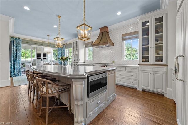 2990 Reynolds Sq, Winston-Salem, NC 27106 - kitchen with ornamental molding, a chandelier, a breakfast bar, a center island with sink, and hardwood / wood-style floors
