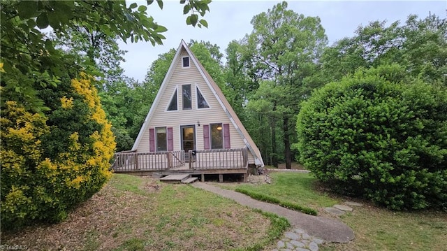 rear view of property with a wooden deck and a yard