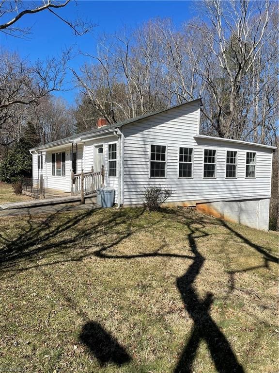 view of front of house featuring a chimney and a front yard