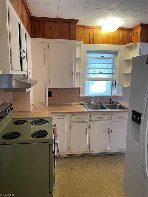 kitchen with electric stove, light countertops, under cabinet range hood, white fridge with ice dispenser, and white cabinetry