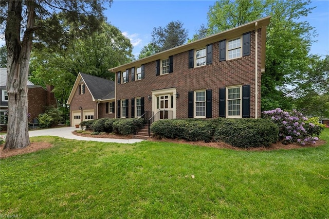 colonial house featuring concrete driveway, brick siding, an attached garage, and a front lawn