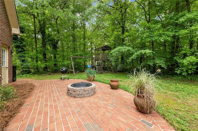 view of patio / terrace featuring a playground and a fire pit