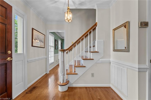 foyer entrance with stairs, baseboards, visible vents, and wood finished floors