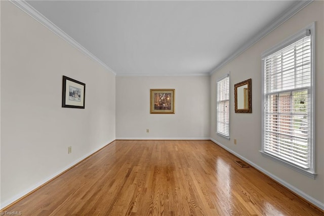 unfurnished room featuring crown molding, baseboards, visible vents, and light wood-style floors