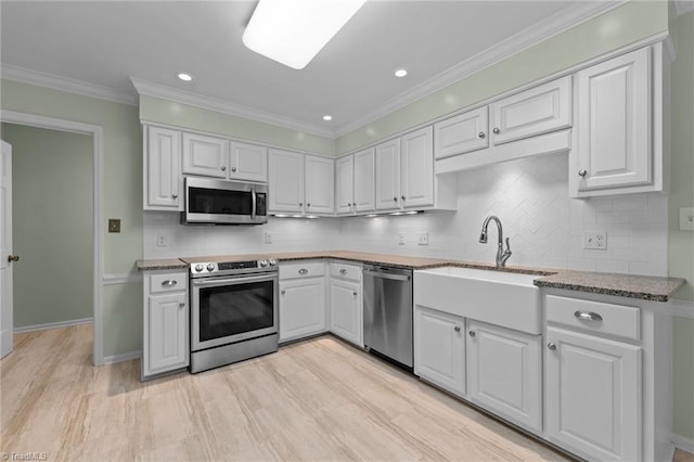 kitchen featuring appliances with stainless steel finishes, white cabinets, backsplash, and recessed lighting