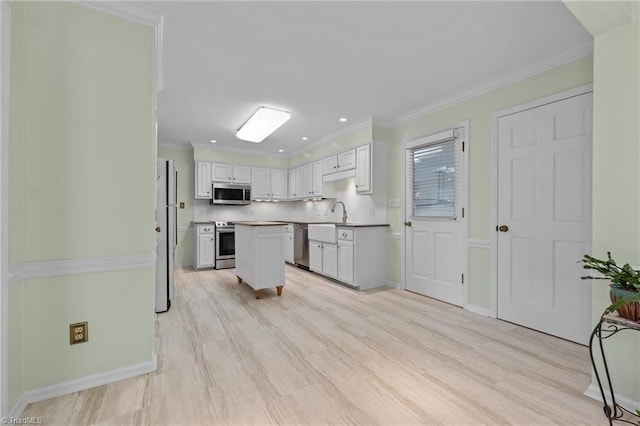kitchen featuring light countertops, light wood finished floors, appliances with stainless steel finishes, and white cabinets