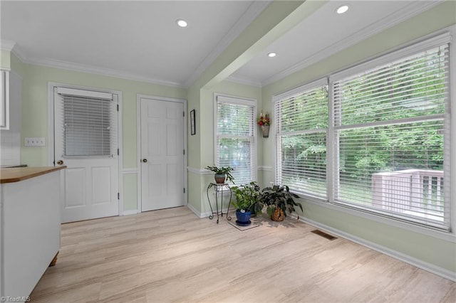 entryway with crown molding, visible vents, baseboards, recessed lighting, and light wood-style flooring