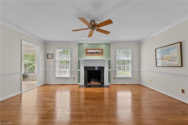 unfurnished living room featuring crown molding, a high end fireplace, ceiling fan, and wood finished floors