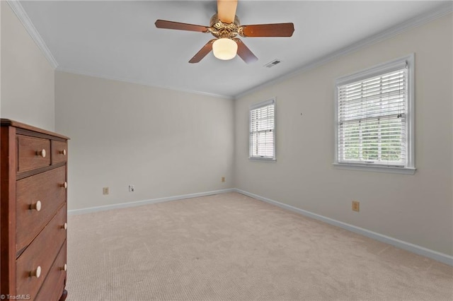 spare room with crown molding, baseboards, and light carpet
