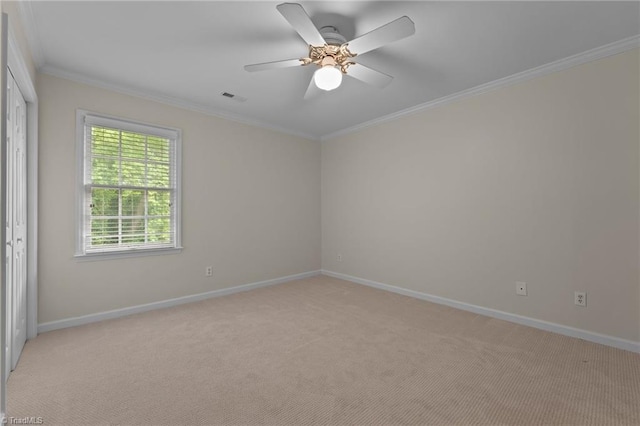 unfurnished room featuring crown molding, baseboards, visible vents, and light carpet
