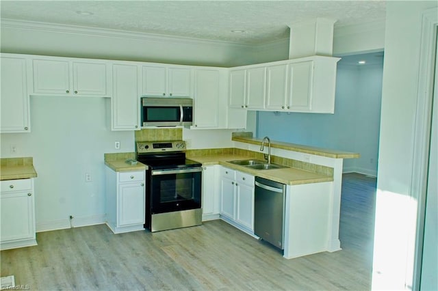 kitchen with white cabinets, sink, stainless steel appliances, and a textured ceiling