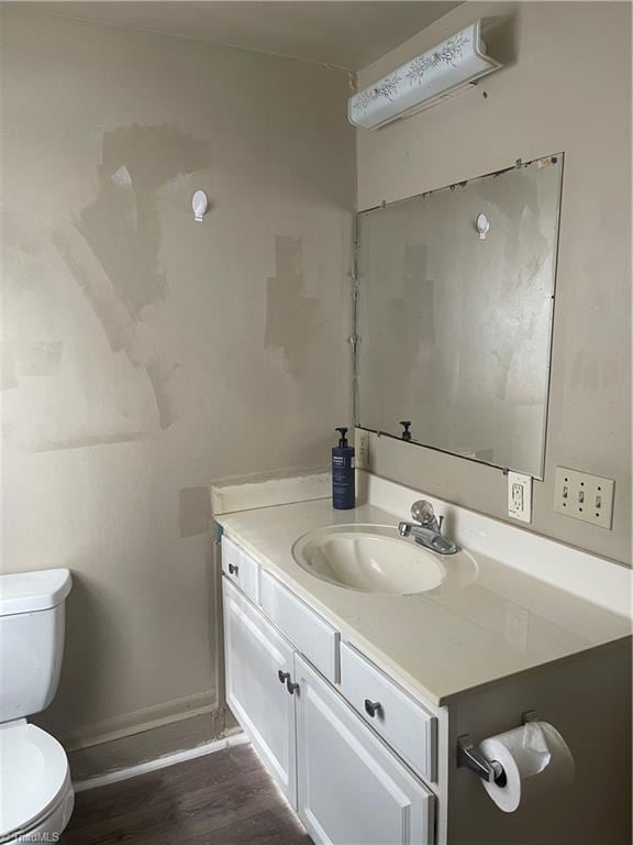 bathroom with hardwood / wood-style floors, toilet, and vanity