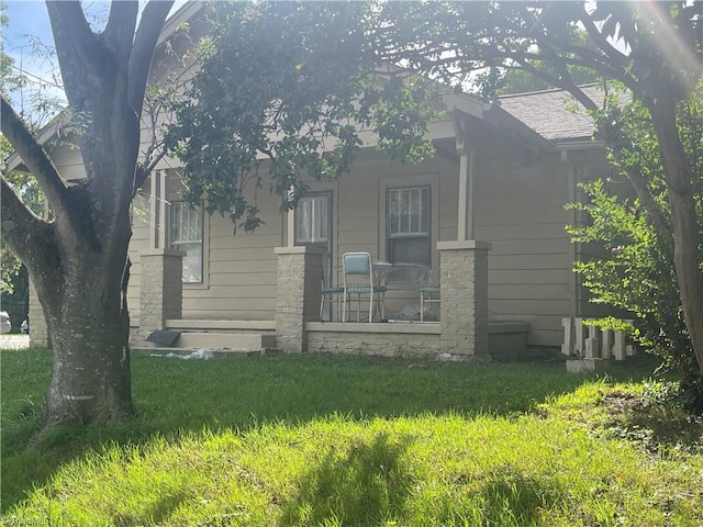 rear view of house featuring a lawn