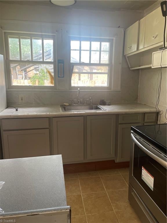 kitchen with a healthy amount of sunlight, electric range, and sink