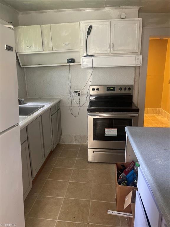 kitchen with stainless steel range with electric stovetop, tile patterned floors, white fridge, crown molding, and exhaust hood