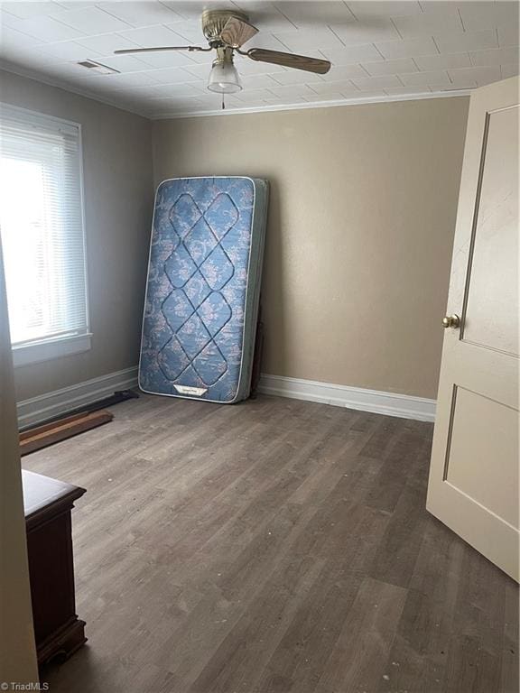 empty room with crown molding, ceiling fan, and dark hardwood / wood-style floors