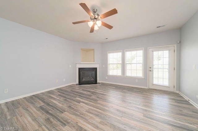 5306 Forester Dr, High Point, NC 27265 - unfurnished living room featuring wood finished floors, a ceiling fan, a fireplace with flush hearth, and baseboards