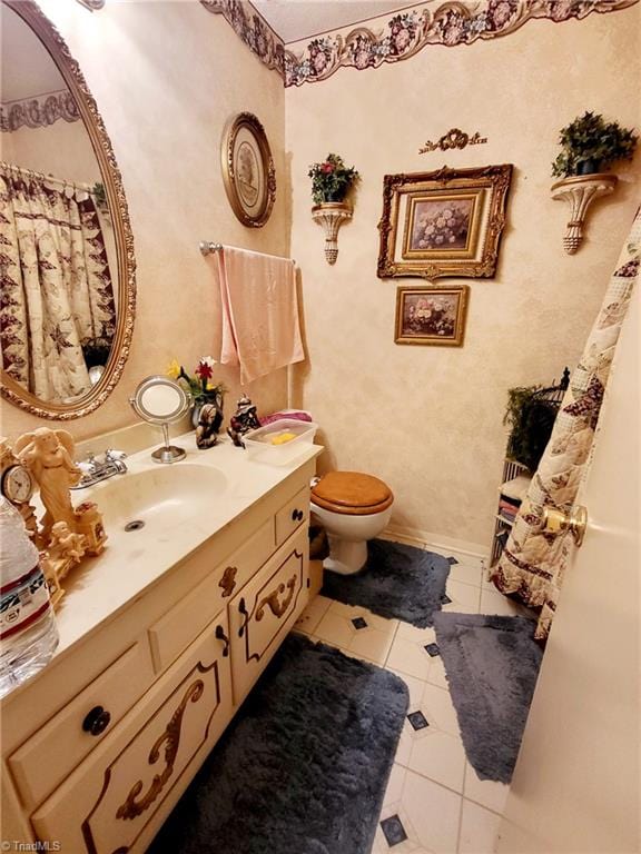 bathroom featuring toilet, tile patterned floors, and vanity