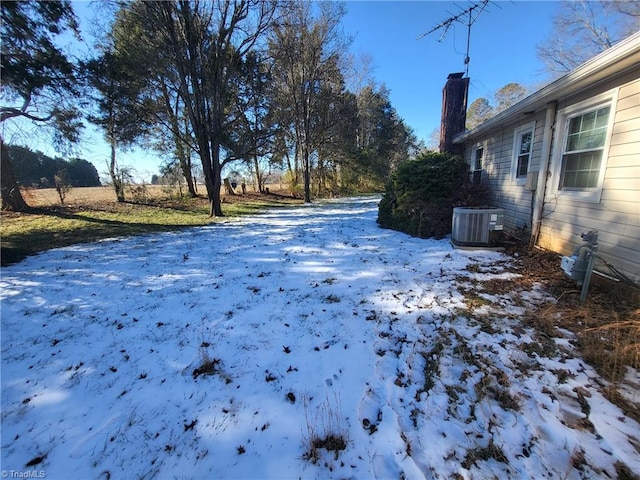 snowy yard featuring cooling unit