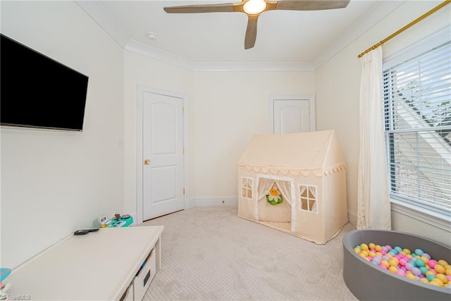 playroom featuring baseboards, light carpet, ornamental molding, and a ceiling fan