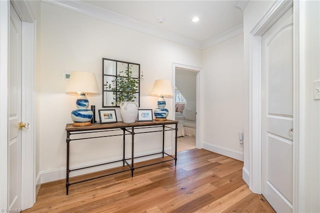 corridor featuring recessed lighting, baseboards, light wood-style floors, and ornamental molding