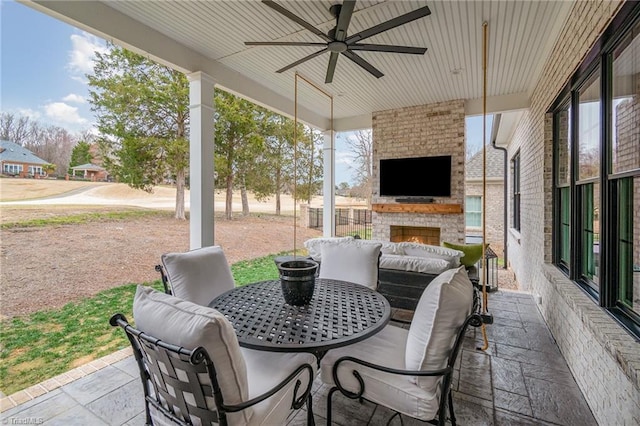 view of patio featuring an outdoor living space with a fireplace and ceiling fan